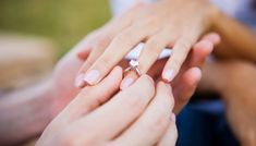 the bride and groom are holding their wedding rings