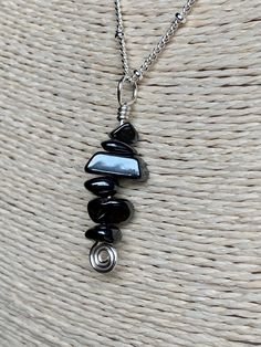 "Gemstone: Genuine Hematite Chips. Wire: Silver Plated with enamel coating to prevent tarnish and color change. Pendant Height: 1 3/8 inches. Pendant Width(at widest point): Approximately 1/4 inch in width (may vary due to the rough cut of the chips). Necklace Length: 18 inches. Necklace closure: Lobster. Necklace style: Satellite Chain. Chain Material: Silver plated brass. Hematite is an iron rich crystal with a gray, silvery color. When polished, it is almost reflective. Derived from the Latin Bohemian Obsidian Jewelry With Natural Stones, Hematite Natural Stone Necklaces For Gifts, Hematite Necklaces With Natural Stones For Gift, Silver Hematite Necklace With Gemstone Beads, Silver Obsidian Jewelry With Gemstone Beads, Adjustable Silver Obsidian Necklace, Hematite Natural Stones Necklace For Gift, Silver Obsidian Gemstone Necklace, Spiritual Silver Obsidian Necklace