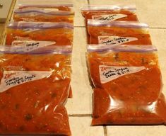 five bags of chili sauce sitting on top of a tiled floor next to each other