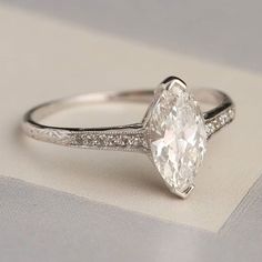 an oval cut diamond ring with pave set shoulders