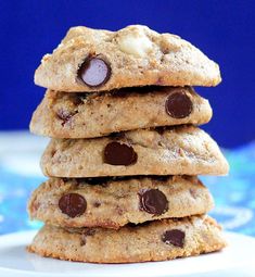 chocolate chip cookies stacked on top of each other in front of a blue tablecloth