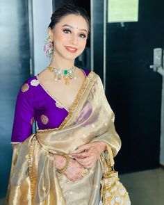 a woman in a purple and gold sari