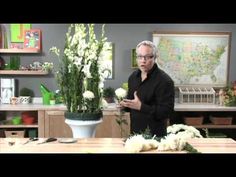 a man standing in front of a table with flowers on it