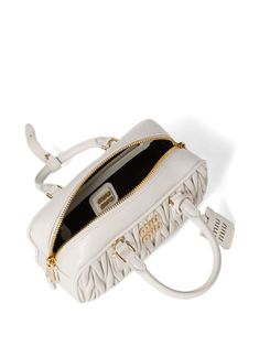 Find MIU MIU Arcadie Bag on Editorialist. The Miu Miu Arcadie bag is crafted from white cotton and leather with matelassé detailing. It features a top zip fastening, two top handles, logo lettering, gold-tone hardware, an adjustable detachable shoulder strap, a satin lining, and an internal zip-fastening pocket. The bag is a small, satchel style that can be worn on the shoulder or carried by hand. White Quilted Top Handle Bag, Luxury Miu Miu Shoulder Bag With Top Carry Handle, White Luxury Bag With Zipper Closure, Luxury White Shoulder Bag With Zipper, Luxury White Shoulder Bag With Zipper Closure, Designer White Shoulder Bag With Zipper Closure, Luxury Miu Miu Bags With Zipper Closure, Luxury White Satchel With Zipper Closure, White Top Handle Satchel With Zipper Closure