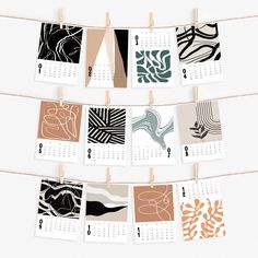 a calendar hanging on a clothes line with different designs