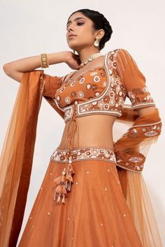 Ochre brown lehenga, accentuated with floral embroidery in cutdana and sequin embellishments. Paired with a half sleeve, sweetheart neckline blouse, highlighted with pearl, cutdana and sequin embellishments in floral pattern. Comes with a floral embroidered border dupatta.
Component: 3
Pattern: Embroidery,Embellished
Type Of Work: Floral,Pearl,Sequin,Cutdana
Neckline: Sweetheart Neck
Sleeve Type: Half Sleeves
Fabric: Silk, Organza
Color: Brown
Other Details: 
Floral embroidered waistband
Fabric Brown Resham Embroidered Sets For Diwali, Brown Resham Embroidery Sets For Diwali, Brown Sets With Resham Embroidery For Diwali, Elegant Brown Festive Sets, Designer Wear Sets With Resham Embroidery In Brown, Brown Dupatta With Resham Embroidery For Navratri, Festive Brown Lehenga With Traditional Drape, Brown Lehenga With Dupatta For Wedding, Festive Brown Lehenga With Dupatta