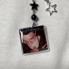 a necklace with an image of a man on it and two stars attached to it