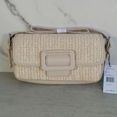 This Compact Natural Straw Shoulder Bag Features A Magnetic Snap- Buckle Style Front Closure. Complimented With Interior Pockets, Card Holder, Signature Lining And Adjustable Strap For Easy Wear. Perfect For Your Summer Resort Vacation. Material- Polyester Straw, Trim- Polyurethane Faux Leather, Lining- Polyester Small Sized Bag, 8.5" W X 4.75" H X 1.75" D Magnetic Snap Closure Strap Type- 6" - 9" Adjustable Shoulder Strap Exterior- Matte Silver Hardware Interior- Signature Logo Lining Weight- 1 Cream Woven Straw Bag For Day Out, Cream Straw Bag With Braided Handles For Day Out, Spring Summer Straw Bag With Detachable Strap, Summer Straw Bag With Detachable Strap For Spring, Rectangular Beige Straw Bag For Day Out, Chic Beige Shoulder Bag For Vacation, Spring Straw Bag With Detachable Strap, Chic Cream Shoulder Bag For Beach, Cream Bags For Day Out In Spring