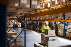 a man in a warehouse with boxes on pallets