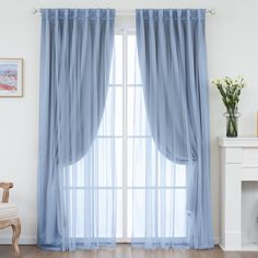 a living room with white walls and blue curtains