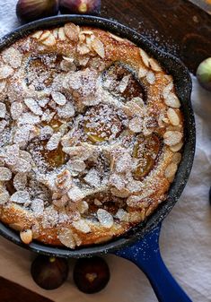 an apple pie with powdered sugar on top in a black cast iron skillet