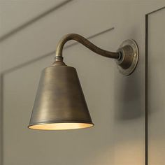 an old fashioned wall light hanging on the side of a door in a room with white walls