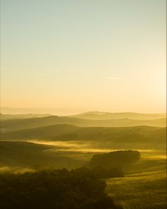 the sun shines brightly over rolling hills