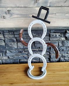 a sculpture made out of horseshoes on top of a wooden table