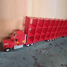 a red toy truck is parked next to a shelf