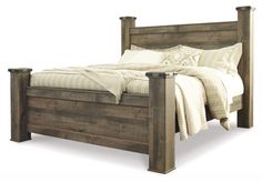 a bed with wooden headboard and foot board on top of it, in front of a white background