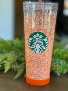 a starbucks cup with glitter on the side and a straw sticking out of it's lid