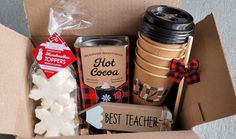 a cardboard box filled with hot cocoa and marshmallows next to a cup of coffee