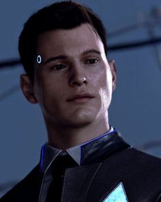 a young man wearing a black suit and tie with blue lights on his forehead, staring at the camera