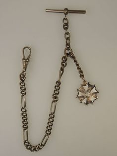 "This is a white metal pocket watch chain which measures 230mm from the T bar to the dog clip and measures 5mm at its widest point. The chain is made up of a single length of curb links interspersed with an oval link. There is also an additional length of chain from which hangs a metal and enamel fob with the words \"Legion of Merit, Hong Kong\".  The chain is in 90% mint condition - light tarnish but still an excellent chain" Victorian Pocket Watch, Victorian Style Self-winding Pocket Watch For Formal Occasions, Victorian Pocket Watch Chain, Antique Self-winding Pocket Watch As Gift, Victorian Self-winding Collectible Pocket Watch, Pirate Halloween, Dog Clip, Pocket Watch Chain, Watch Chain