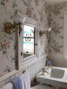 a white sink sitting under a bathroom mirror