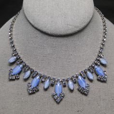 *Description: This is a gorgeous blue rhinestone necklace with blue art glass cabochons on a rhodium plated background from the 1960s. Each of the blue rhinestones and art glass cabochons are prong set. The necklace is adjustable up to 15 inches. It is in excellent condition. This would be a great addition to your vintage jewelry collection or make a great vintage gift! *Approximate Measurements: Length - 15 Inches, Width in Front - 1 Inch, Weight - .8 Ounces *Condition: Great vintage condition. Zelda Au, Pearl Necklace Earrings, Mother Of Pearl Necklace, Pretty Necklaces, Choker Necklaces, Pink Rhinestones, Blue Rhinestones, Blue Art, Rhinestone Necklace