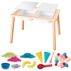 a wooden table with two bowls, spoons and other play food items on it