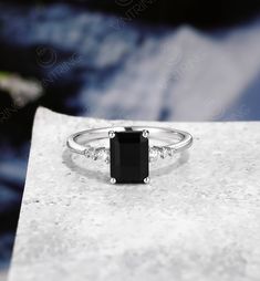 a black and white diamond ring sitting on top of a table