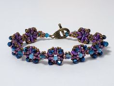 Purple Flower-shaped Beaded Bracelets, Purple Flower Shaped Beaded Bracelets, Elegant Handmade Flower Beaded Bracelets, Bohemian Beaded Bracelets With Bead Caps As Gift, Purple Beaded Flower Bracelets, Elegant Multicolor Flower Beaded Bracelets, Elegant Beaded Bracelets With Flower-shaped Spacer Beads, Bohemian Bracelets With Bead Caps For Gifts, Adjustable Bracelets With Bead Caps As Gift