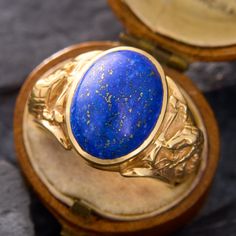 This mens statement ring showcases an oval lapis cabochon with plenty of pyrite flecks. The lapis is bezel-set into a ring with hissing cobra details on each shoulder. The ring is crafted in 14k yellow gold and is currently a size 8.75. Formal Lapis Lazuli Oval Rings, Oval Lapis Lazuli Rings For Formal Occasions, Luxury Lapis Lazuli Oval Rings, Luxury Oval Lapis Lazuli Rings, Luxury Oval Lapis Lazuli Jewelry, Golden Rings For Men, Kubler Ross, Golden Rings, Serpent Ring