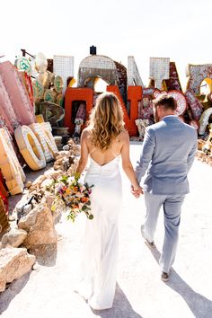 Step back in time with this enchanting shot of a couple at a neon museum! 🌟 Her timeless wedding dress, with delicate spaghetti straps and soft waves, is a true vision. His smart-casual gray suit perfectly complements the setting. The lush bouquet adds a burst of color against the nostalgic neon signs. Ready for unique wedding ideas? 🌺👗✨ #weddingdresses #weddingideas #timelessweddingdress #weddinghairstyles #uniqueweddingideas