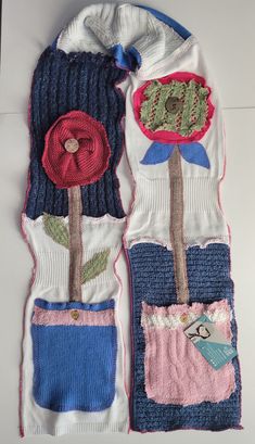 two knitted gloves with flowers on them