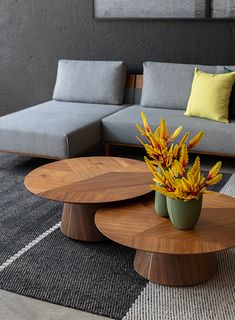 a living room with couches, tables and flowers in vases on the coffee table