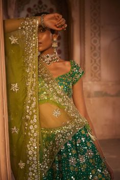 Make a statement with this stunning green raw silk lehenga featuring an elegant floral pattern embellished with zari and lime green resham thread. The fully embellished blouse adds a touch of sophistication with bead detailing on the borders. To complete the look, the ensemble includes an organza dupatta in a contrasting lime color, creating a captivating and stylish outfit for special occasions. Lehenga And Blouse, Colour Composition, Raw Silk Lehenga, Green Lehenga, Vacuum Storage, Indian Wedding Wear, Lehenga Blouse, Yellow Silk, Glamour Dress