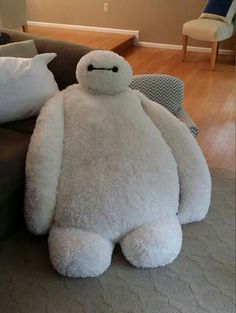 a large white stuffed animal sitting on top of a couch