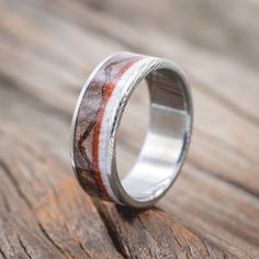 a wedding ring with red and white wood inlays on the inside of it