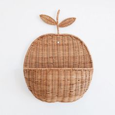 an apple shaped wicker basket hanging on the wall