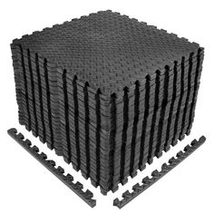 a large pile of black foam tiles on top of each other