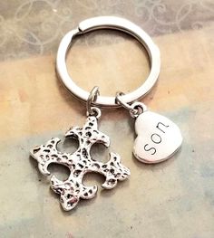 a silver keychain with a heart and an i love you charm on it