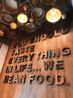 the words mean food are written in cursive letters on a wood floor with hanging lights