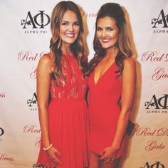 two beautiful women standing next to each other on a red carpet