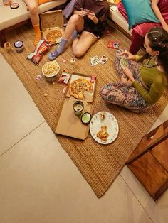 three women sitting on the floor eating pizza