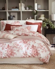 a bed with red and white comforters in a bedroom