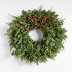 a green wreath with pine cones on it