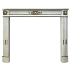 a white marble fireplace with gold trimmings on the top and bottom, against a white background