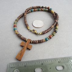 "I designed this earthy looking casual cross necklace for men and women, by combining natural materials: Robles wood cross in shade of light to dark brown, Bloodstone round beads in multi-colors of green, mustard, maroon, tan etc. with characteristic red spots which said to be blood of Christ in legend, and coconut palm wood beads in a brown hue. I have also added some antiqued brass spacers for a touch of vintage look, and finished off with a lobster clasp in antiqued brass. Lead-safe. The pict Brown Bohemian Cross Necklace, Bohemian Brown Cross Necklace, Artisan Brown Cross Jewelry, Adjustable Brown Cross Necklace, Brown Spiritual Necklace With Cross Pendant, Brown Crucifix Necklace In Spiritual Style, Spiritual Brown Crucifix Necklace, Spiritual Brown Cross Necklace, Brown Wooden Beads Cross Necklace