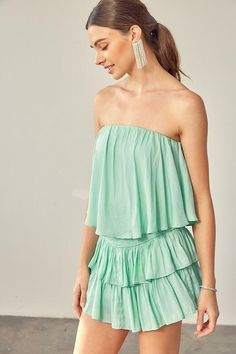 STYLE INFORMATION: The Monaco Milky Green Strapless Romper is a vacay dream! Light green woven fabric falls from a strapless neckline, with no-slip strips, to a flowy, ruffle overlay bodice with an on-trend smocked overlap back detail. Attached shorts complete the look. DETAILS & CARE: Lined Polyester/Rayon. Hand wash cold. Imported. SHIPPING: We offer free shipping for all orders in the Continental US. Green Strapless Tube Top For Day Out, Strapless Green Tube Top For Day Out, Strapless Smocked Back Tube Top For Summer, Strapless Tube Top With Smocked Back For Summer, Chic Smocked Back Tube Top For Summer, Chic Summer Tube Top With Smocked Back, Summer Off-shoulder Smocked Back Tube Top, Summer Off-shoulder Tube Top With Smocked Back, Off-shoulder Smocked Back Tube Top For Summer