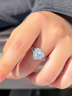 a woman's hand with a diamond ring on top of her finger and an engagement band