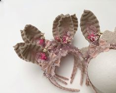 two headbands with pink flowers and sequins are on a white surface