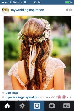 the back of a woman's head with long hair and flowers in her hair